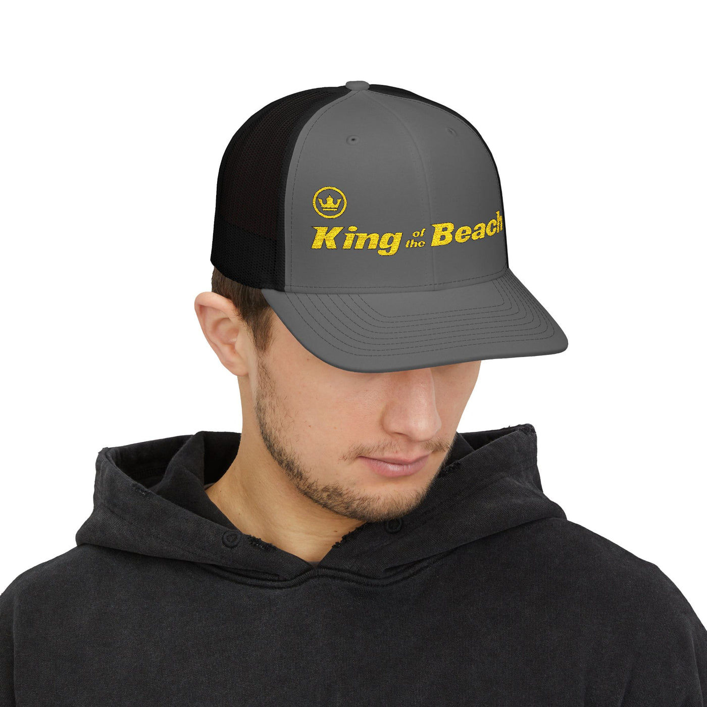 Man wearing a cap with 'King of the Beach' text on a white background
