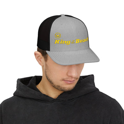 Man wearing a black and gray cap with 'King of the Beach' text on a white background