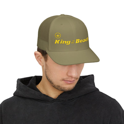 Man wearing a green cap with 'King of the Beach' text on a white background