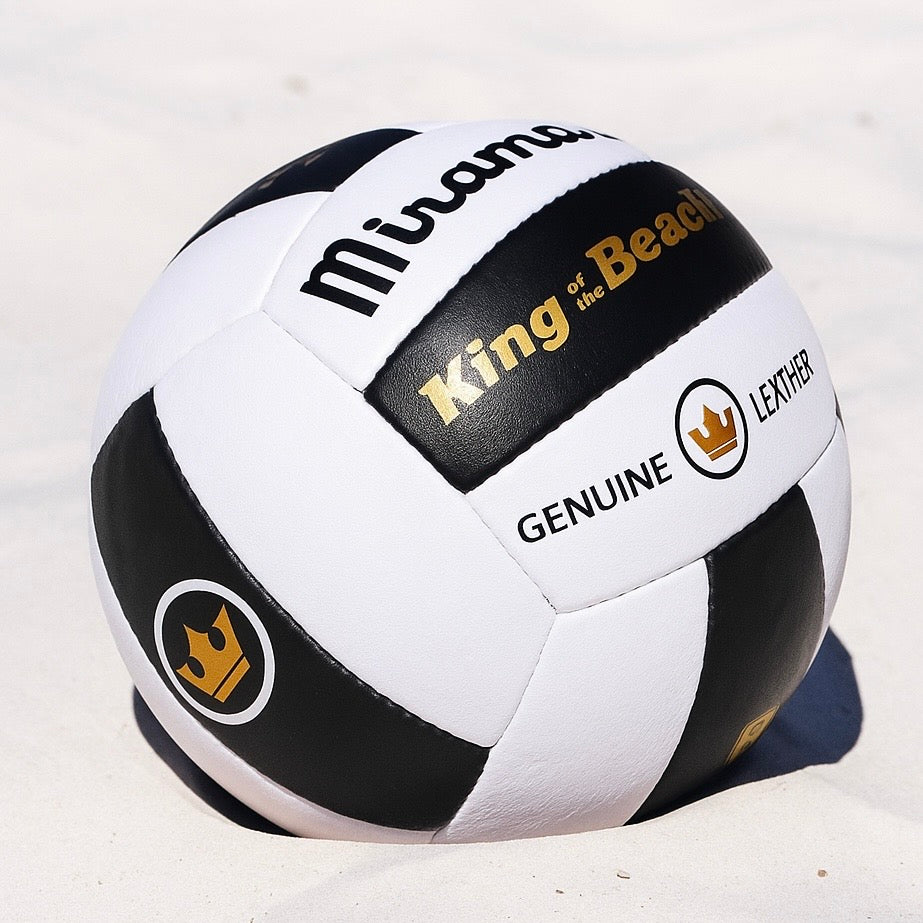 Black and white Miramar genuine leather beach volleyball with 'King of the Beach' branding on a sandy background