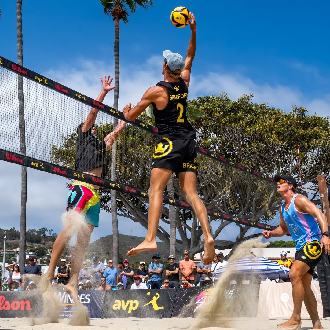 Beach volleyball player in action with a net and spectators in the background