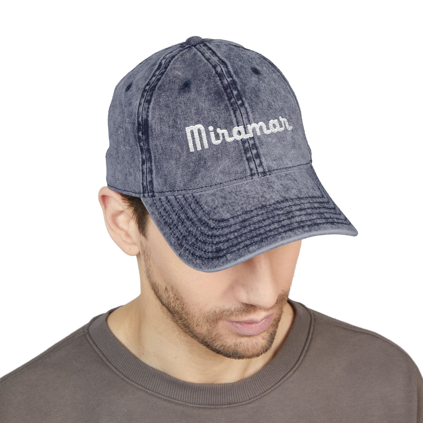 Man wearing a blue denim cap with 'Miramar' logo on a white background